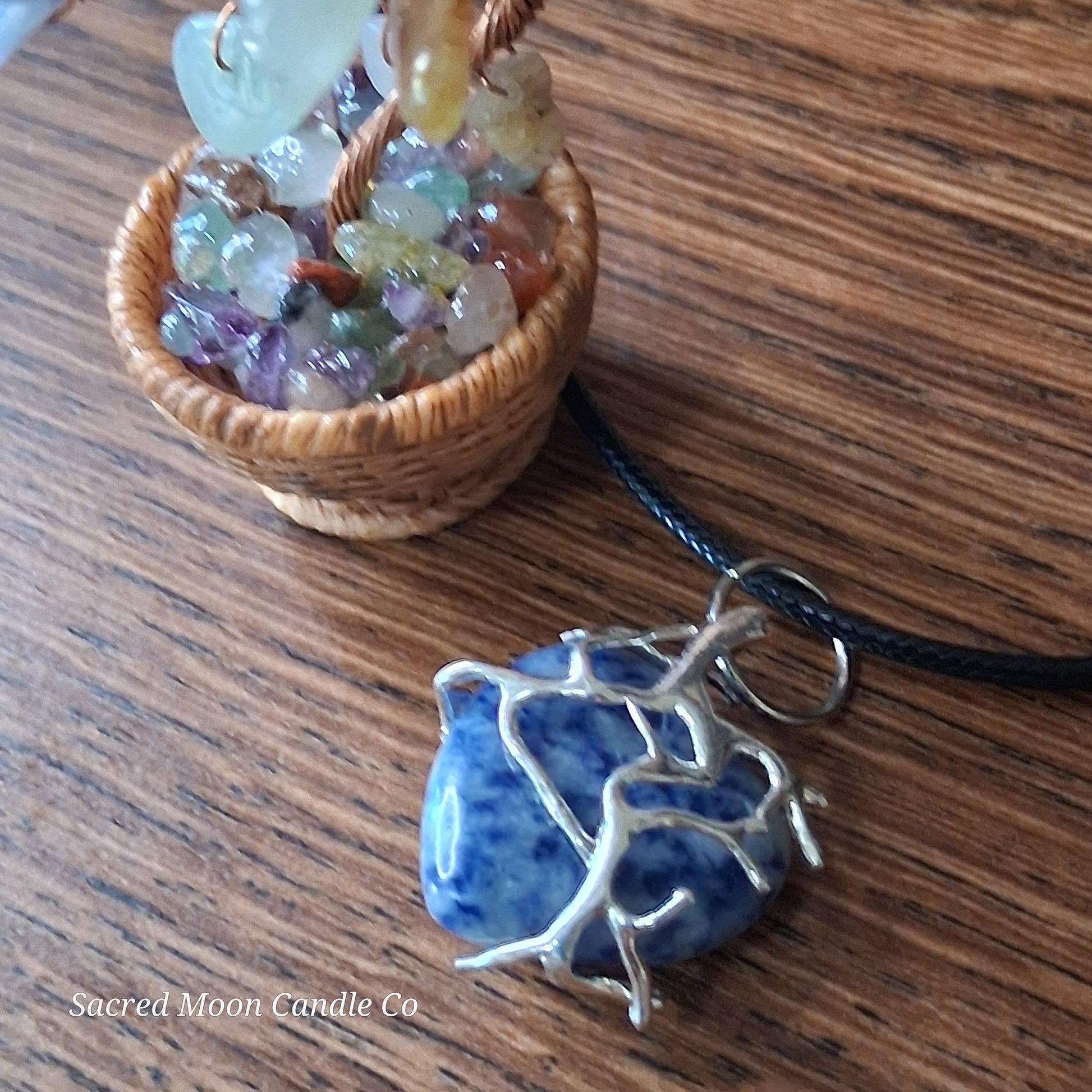 Lapis Lazuli Tree Branch Wrapped Heart Stone Pendant Necklace by Sacred Moon Candle Co on wooden surface with small basket