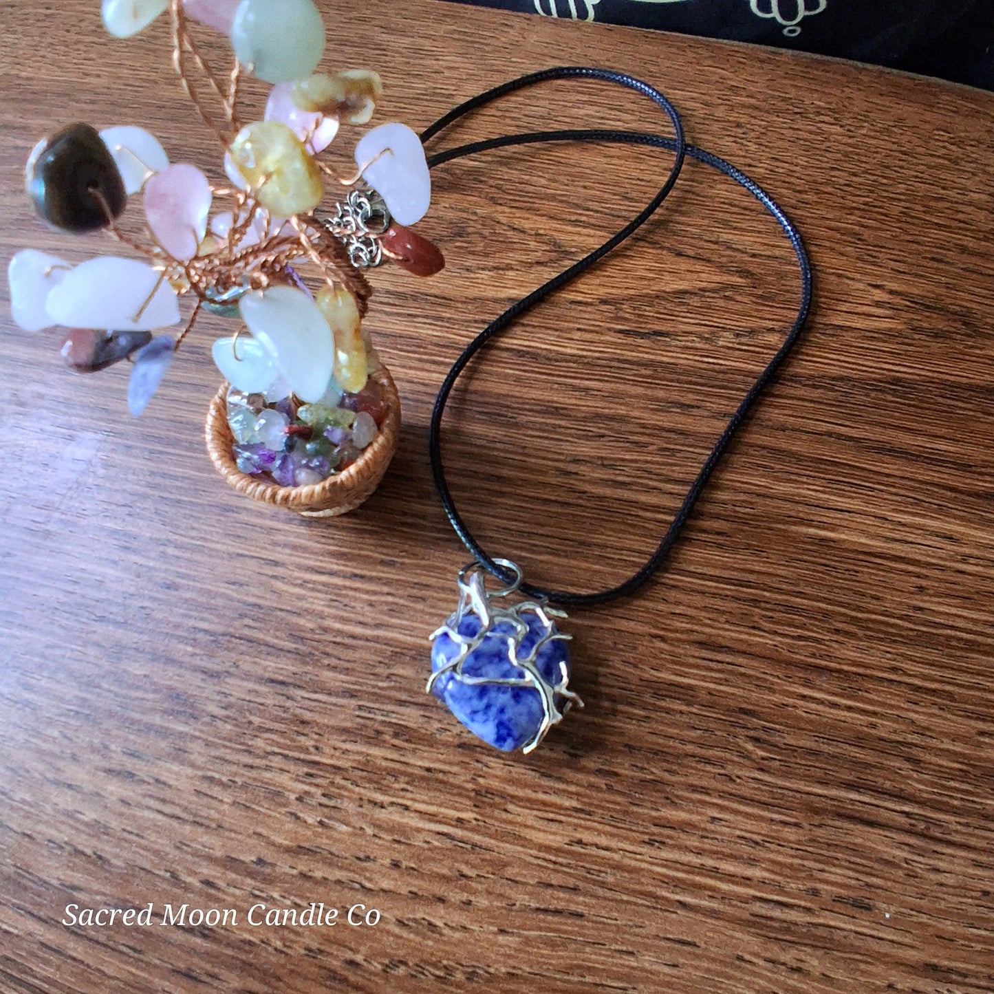 Lapis Lazuli Tree Branch Wrapped Heart Stone Pendant Necklace by Sacred Moon Candle Co on wooden surface