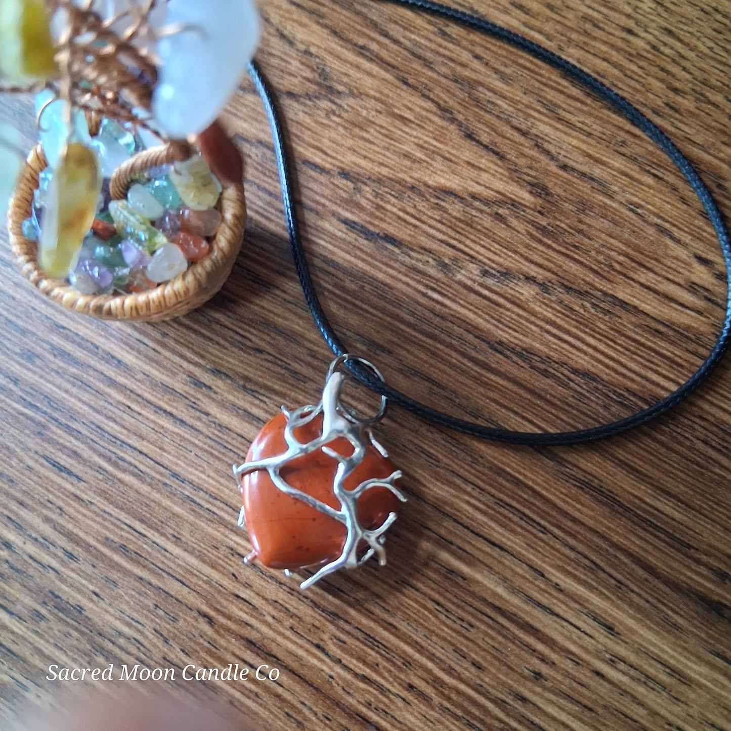 Red Jasper Tree Branch Wrapped Heart Stone Pendant Necklace by Sacred Moon Candle Co on wooden surface