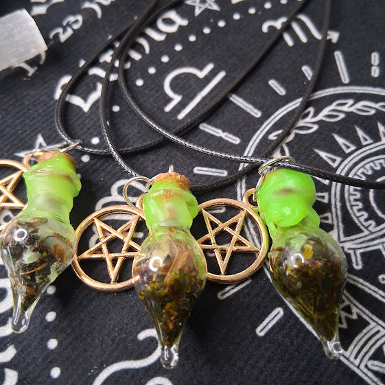 Prosperity spell bottle necklace from Sacred Moon Candle Co with green-topped glass vials and pentagram charms