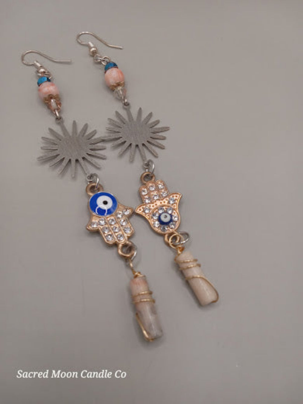 Sunburst Hamsa evil eye earrings with silver sunburst and blue eye charms by Sacred Moon Candle Co