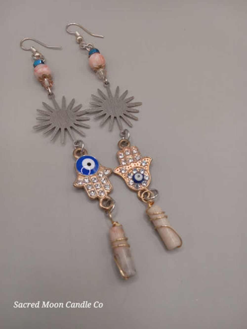 Sacred Moon Candle Co Sunburst Hamsa evil eye earrings with blue stones and crystal accents