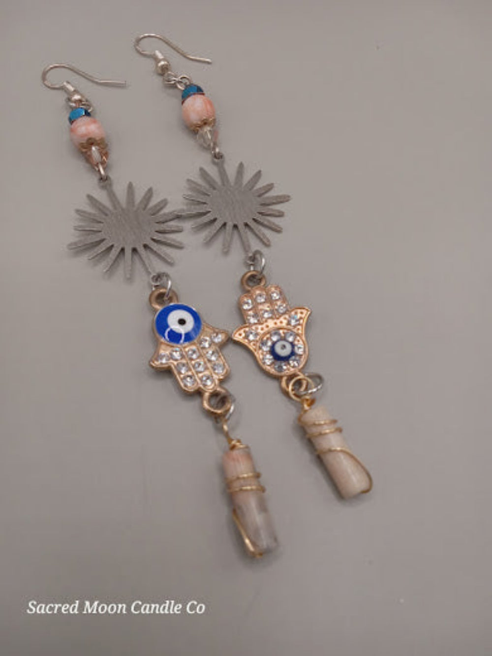 Sunburst Hamsa evil eye earrings by Sacred Moon Candle Co featuring blue eye beads and dangling accents
