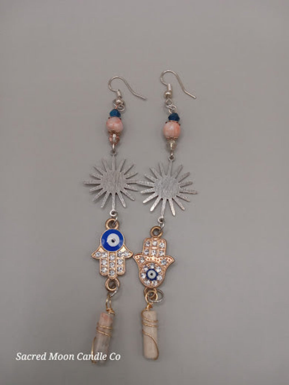 Sunburst Hamsa evil eye earrings by Sacred Moon Candle Co with blue and pink beads and dangling charms