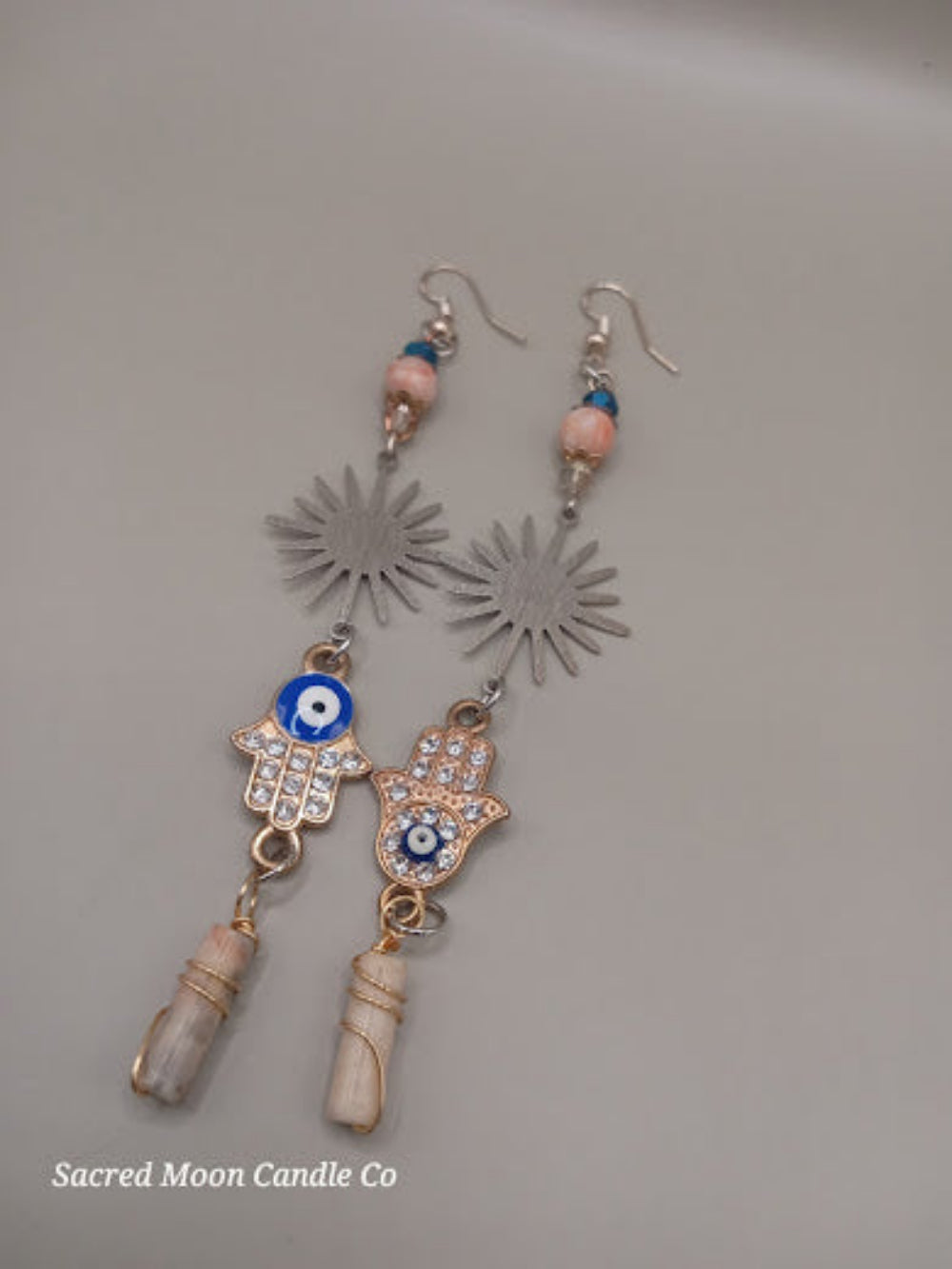 Sunburst Hamsa evil eye earrings by Sacred Moon Candle Co with blue beads and stone pendants