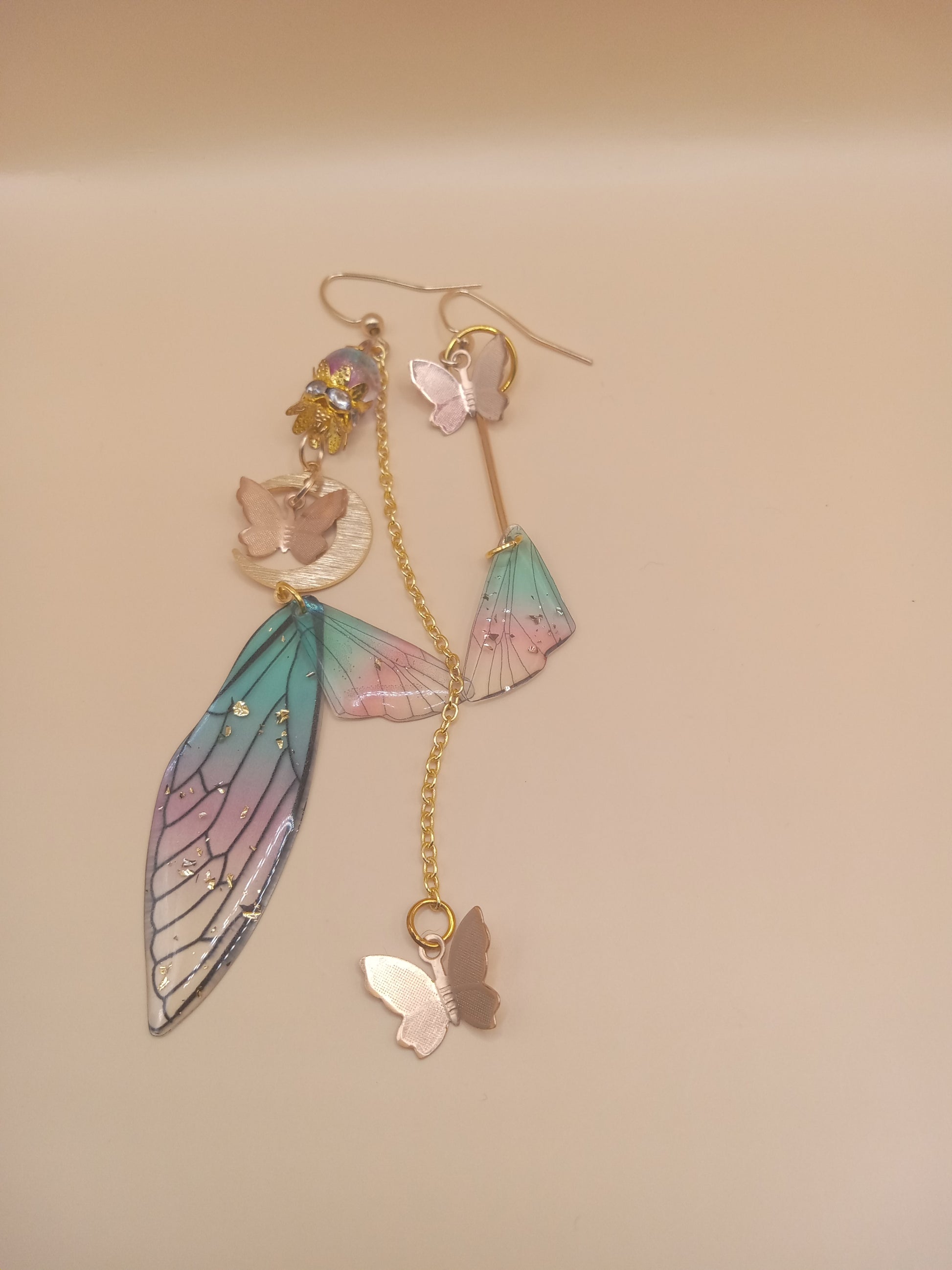 Sacred Moon Candle Co fairy wing earrings with pastel blue and pink delicate wings and gold butterfly charms