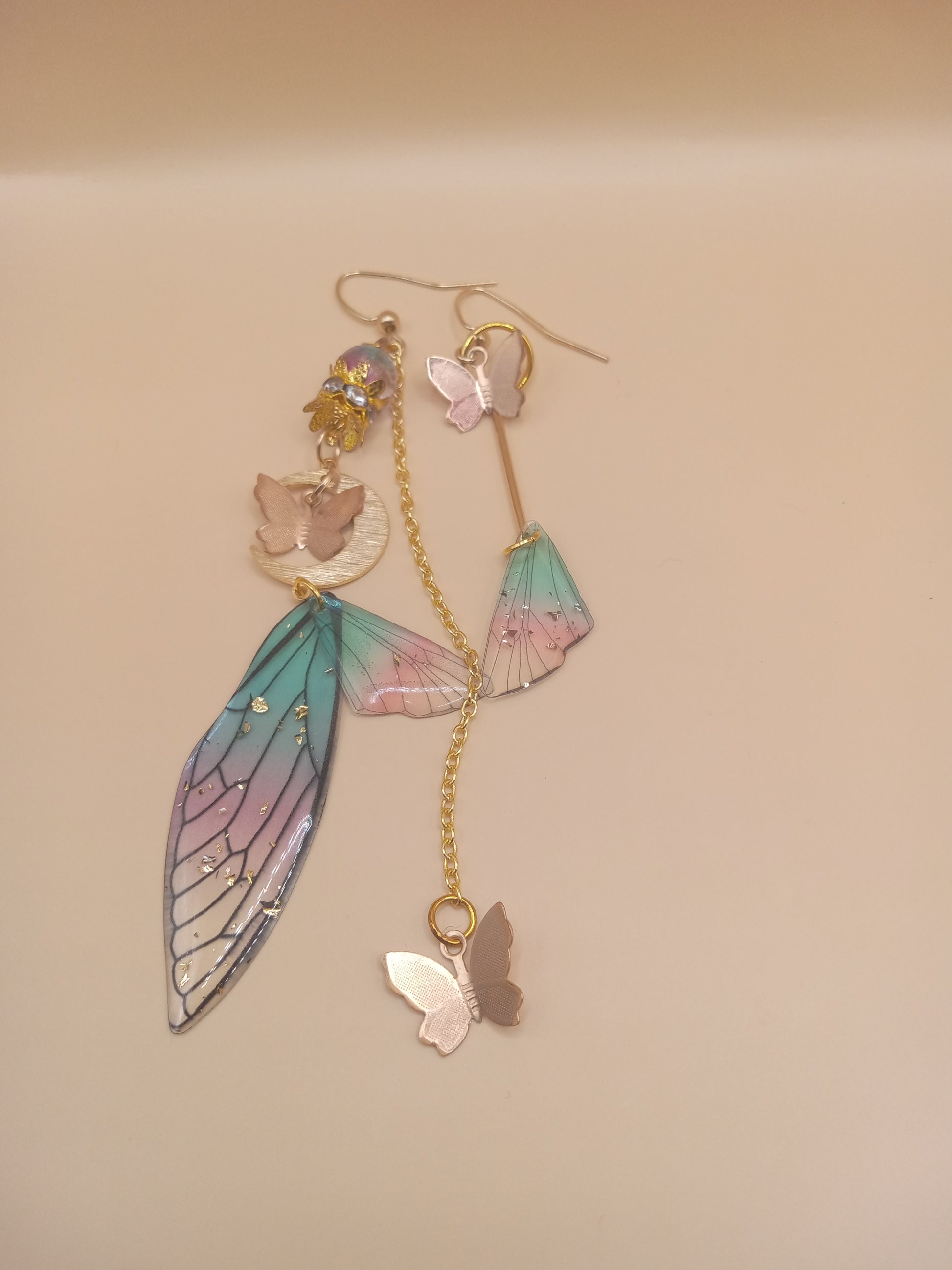 Sacred Moon Candle Co fairy wing earrings with pastel colors and gold chain details