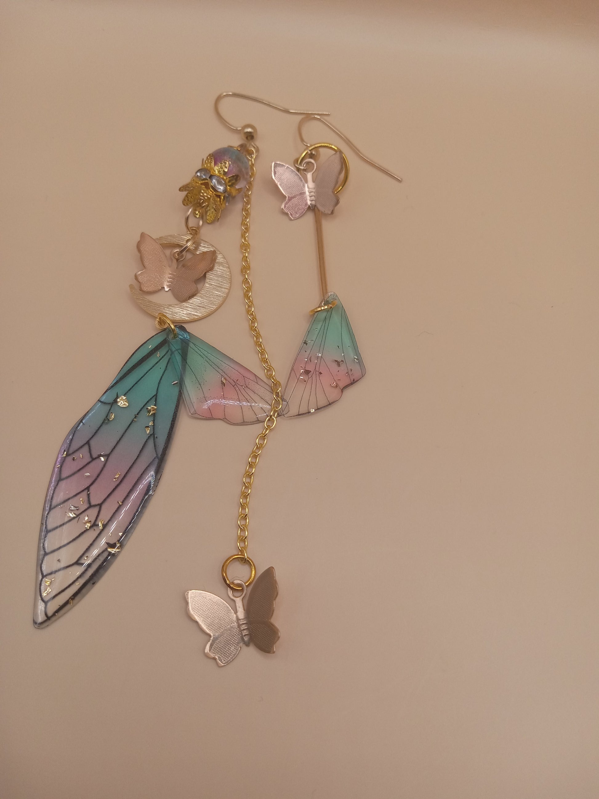 Sacred Moon Candle Co fairy wing earrings with pastel blue and pink wings and butterfly charms