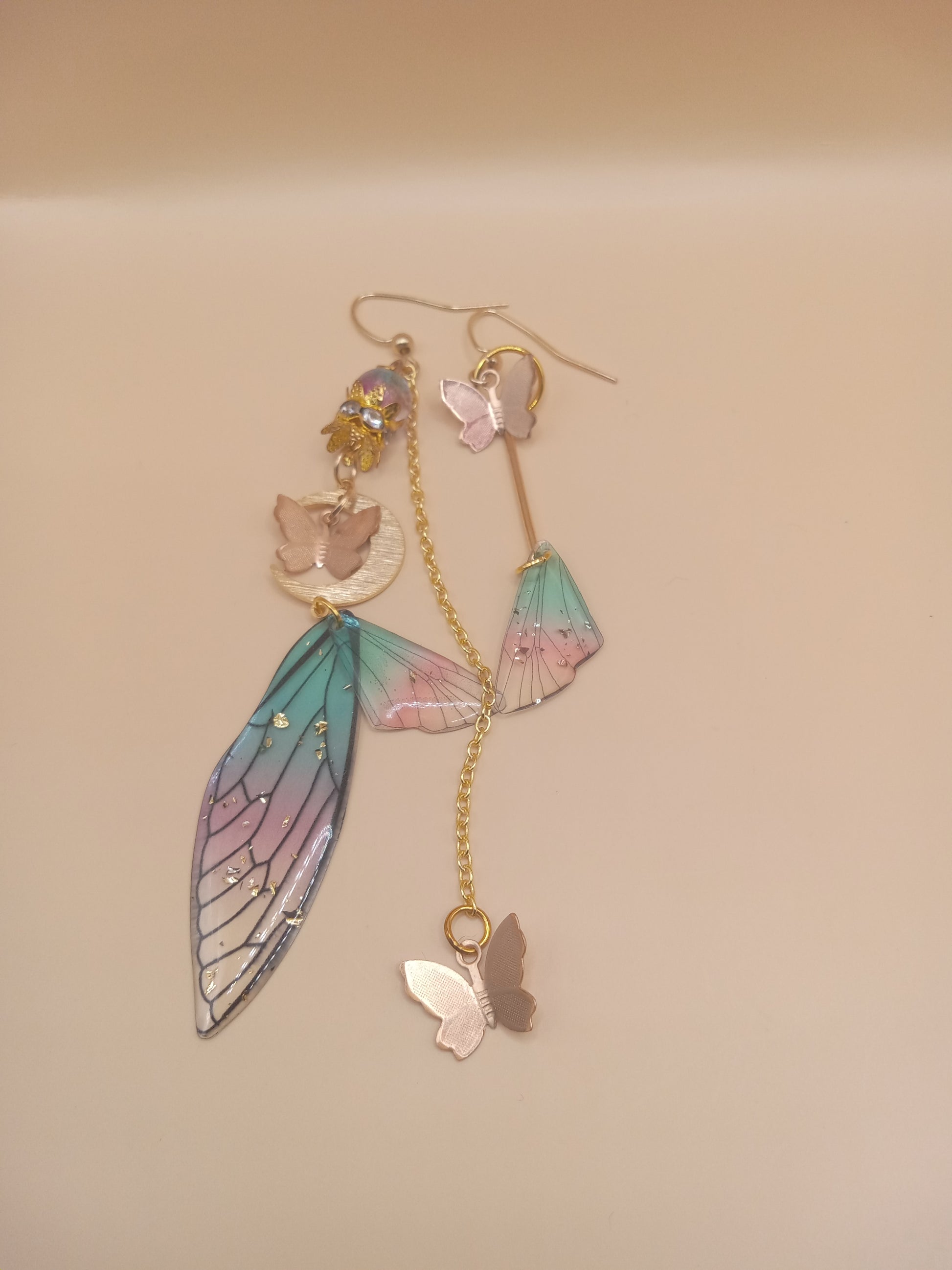 Sacred Moon Candle Co fairy wing earrings with pastel blue and pink wing charms and butterfly accents