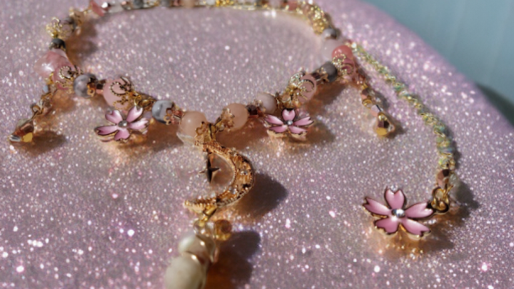 Sacred Moon Candle Co sakura blossom moon choker with pink floral charms on sparkling background