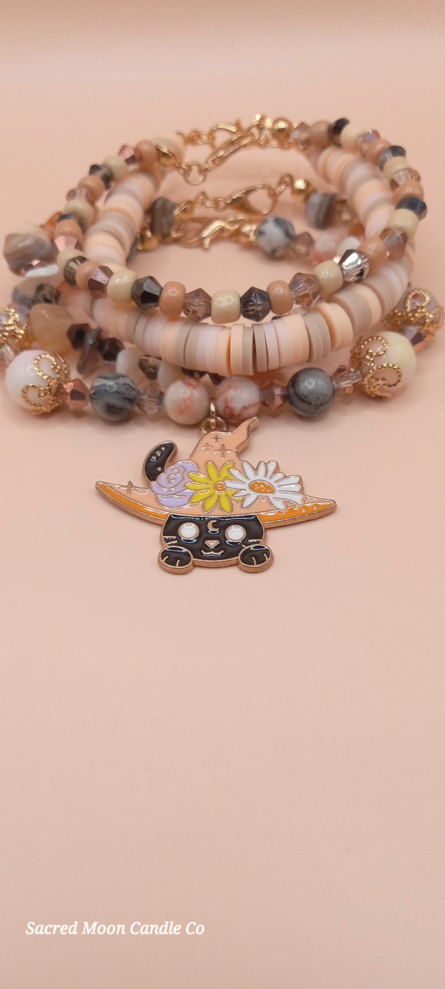 Witchy cat charm bracelet stack by Sacred Moon Candle Co with beads and flower details