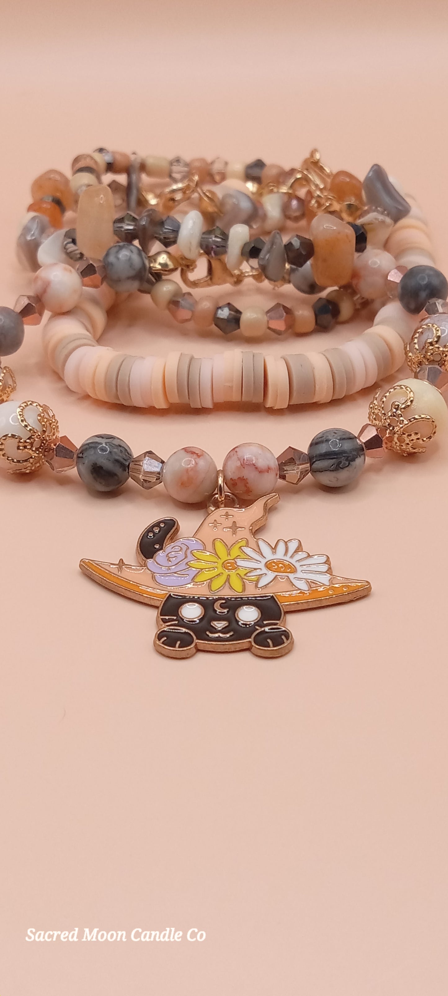 Sacred Moon Candle Co bracelet stacks featuring a witchy cat charm bracelet with assorted beads and charms