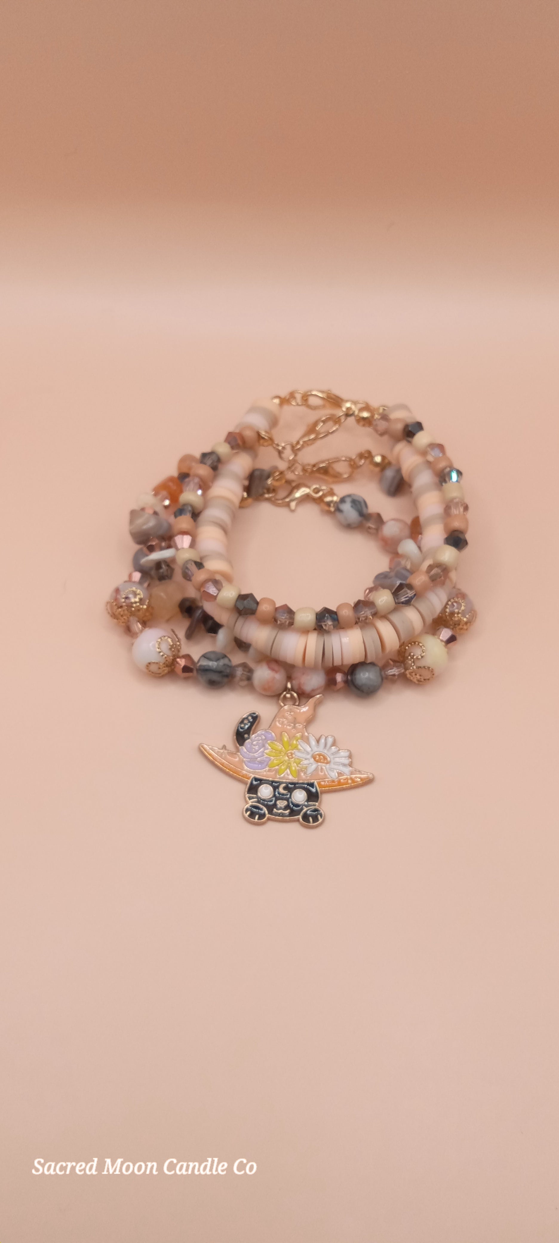 Sacred Moon Candle Co witchy cat charm bracelet stack with beige and gray beads and gold accents