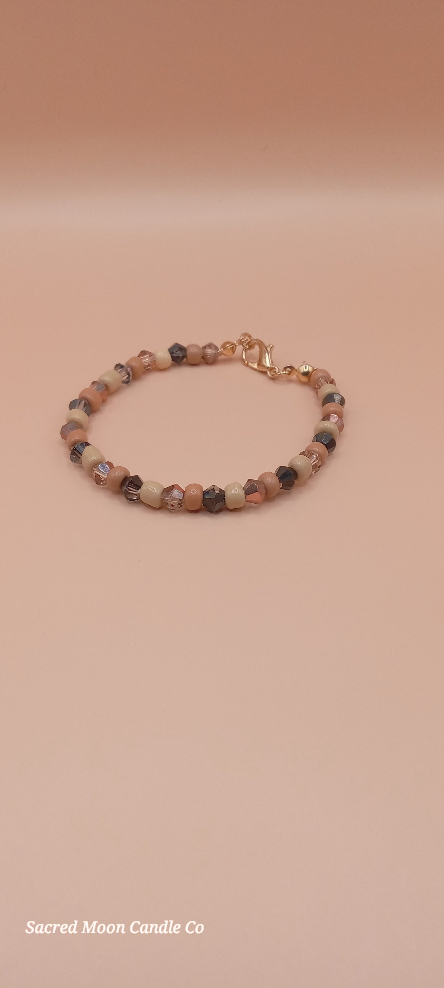 Sacred Moon Candle Co bracelet stack featuring witchy cat charm bracelet with earthy bead design