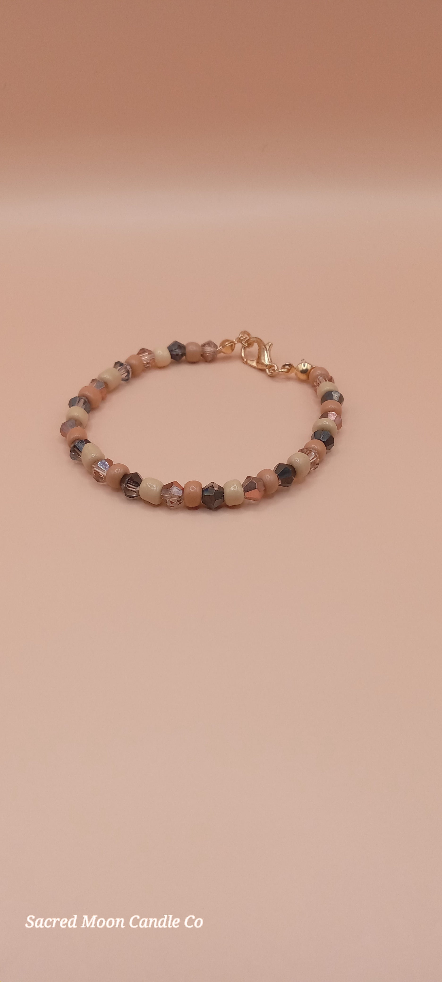 Sacred Moon Candle Co bracelet stack featuring witchy cat charm bracelet with earthy bead design