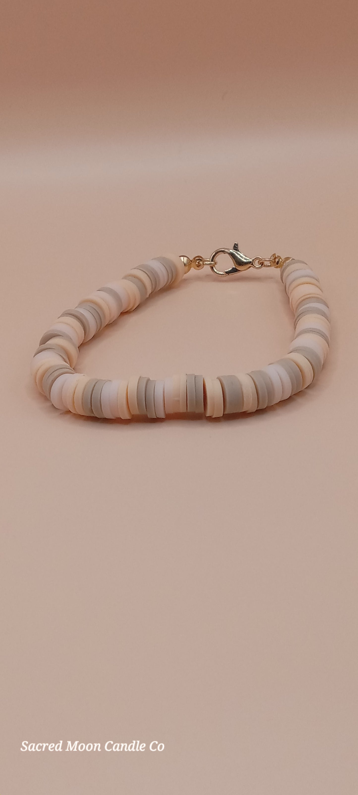 Sacred Moon Candle Co bracelet stacks featuring a witchy cat charm bracelet with neutral flat beads and gold clasp