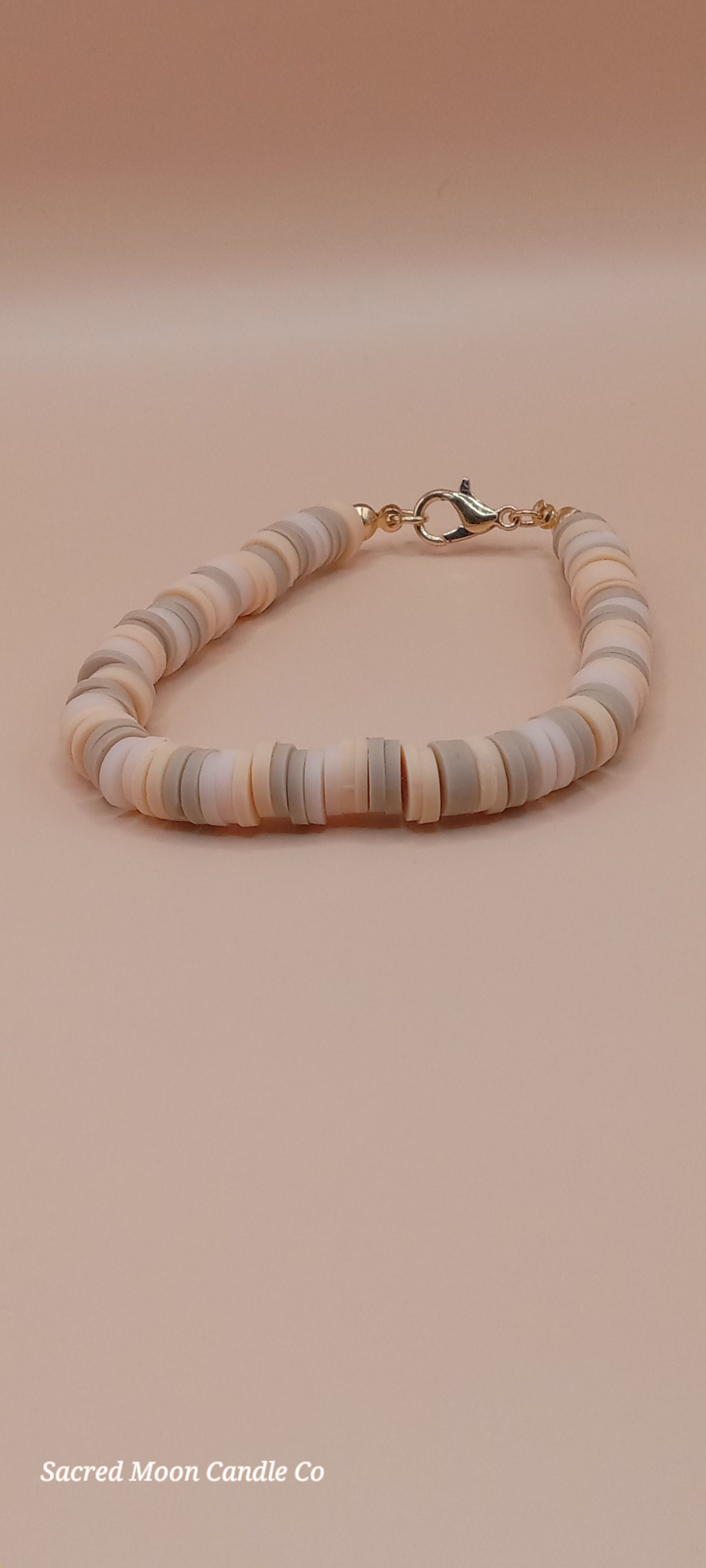 Sacred Moon Candle Co bracelet stacks featuring a witchy cat charm bracelet with neutral flat beads and gold clasp