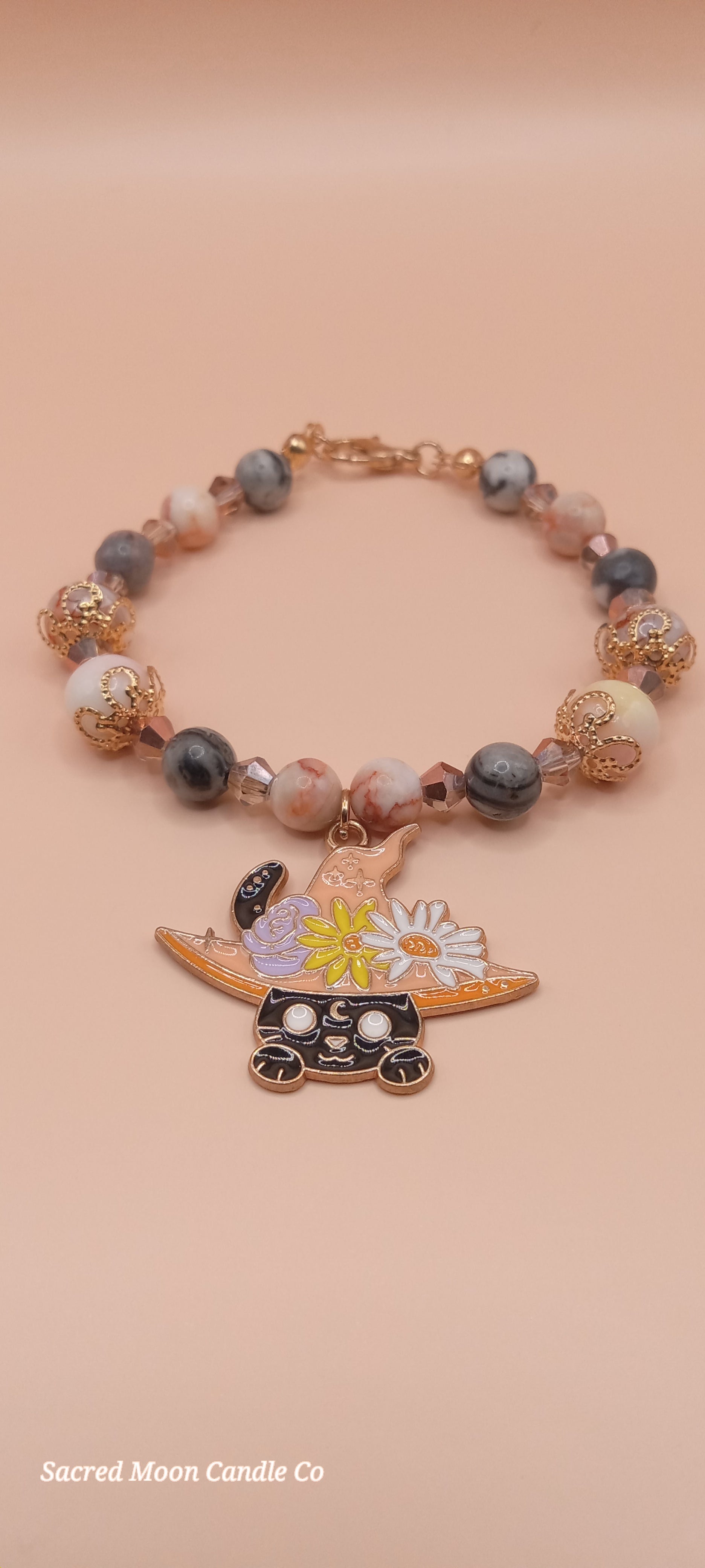 Sacred Moon Candle Co witchy cat charm bracelet with multicolored beads and floral cat charm